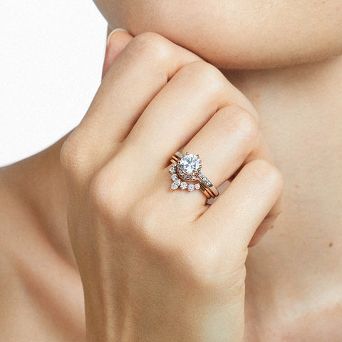 A hand wearing a band and engagement ring with marquise shaped white diamonds with round white diamond set in yellow gold and a round solitaire engagement ring., Available in Yellow Gold, Rose Gold, White Gold. 5