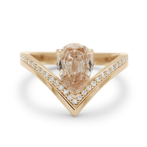 A pear champagne diamond set on top of a chrysalis band with white diamond pave set in yellow gold.