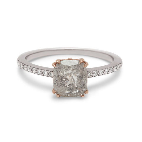 A solitaire ring with a cushion cut grey diamond set in a rose gold basket with white diamond pave on the white gold band.