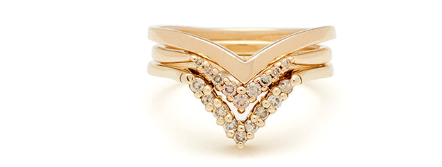 A nesting stack of 3 wedding bands in yellow gold and champagne diamonds with chevron shapes.