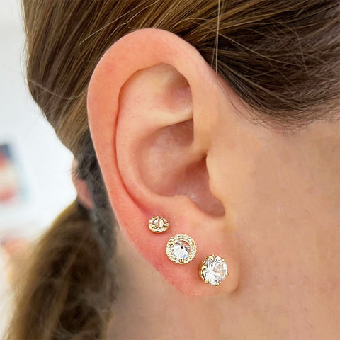 Three white diamond stud earrings on a light-complexion models right ear., White Gold, Rose Gold, Yellow Gold 3