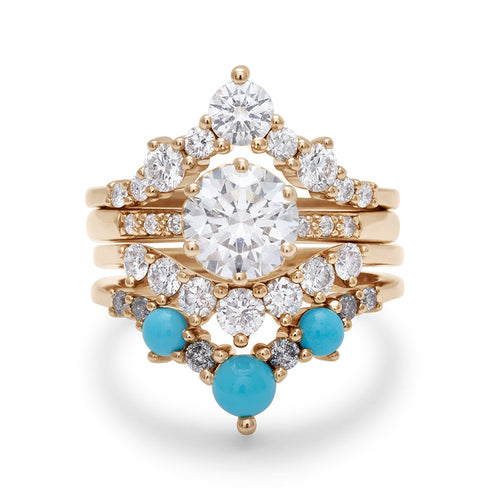 A solitaire round white diamond engagement ring stacked between two chevron bands and a curve band with white diamonds and turquoise stones.