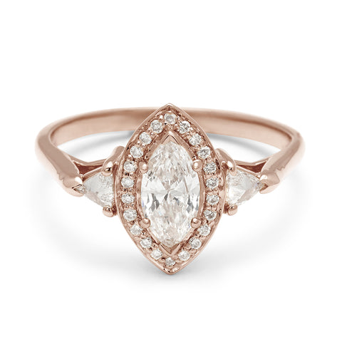 A three stone engagement ring with a marquise shape 0.50ct white diamond center stone surrounded by a white diamond pave halo with two white diamond trillion side stones set in rose gold., Rose Gold 3