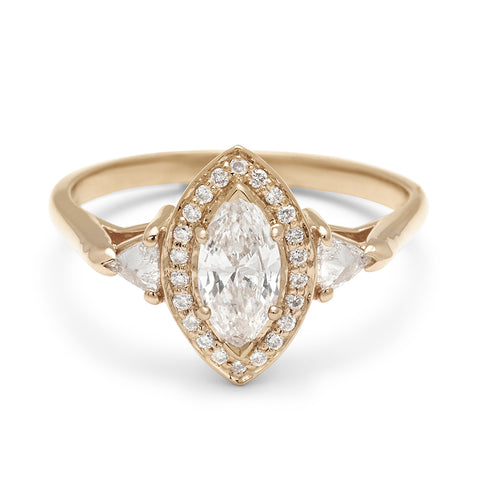 A three stone engagement ring with a marquise shape 0.50ct white diamond center stone surrounded by a white diamond pave halo with two white diamond trillion side stones set in yellow gold., Yellow Gold