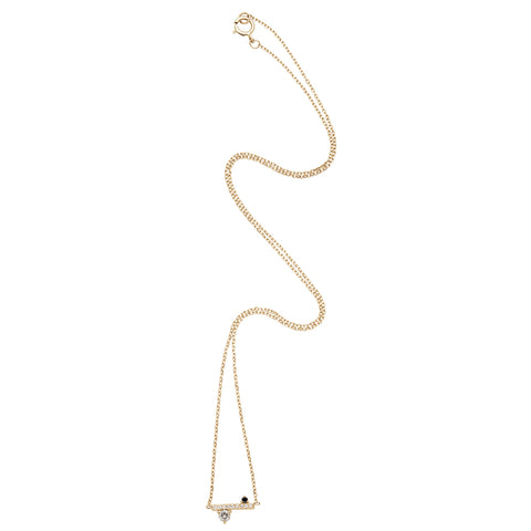 A zoomed out view of a straight line of white diamond pave with grey and black diamond accent stones on either side set in a yellow gold necklace chain. 2