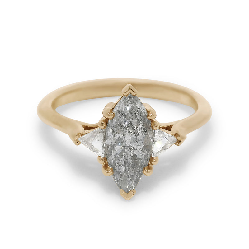 Three stone ring featuring a marquise cut grey diamond with white trillion diamond side stones set in yellow gold.