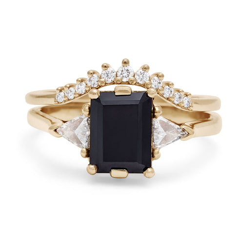 A three stone engagement ring with an emerald cut and emerald shape 8x6mm black diamond center stone with two white diamond trillion side stones set in yellow gold above a tiny white diamond curve band with 11 stones., White Gold, Rose Gold, Yellow Gold