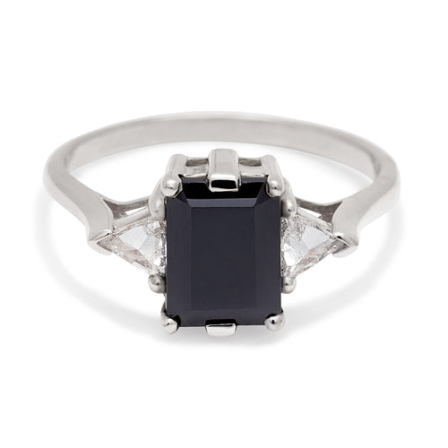 A three stone engagement ring with an emerald cut and emerald shape 8x6mm black diamond center stone with two white diamond trillion side stones set in white gold., White Gold