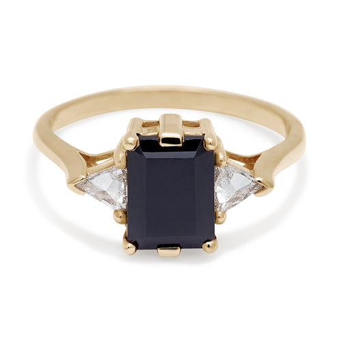 A three stone engagement ring with an emerald cut and emerald shape 8x6mm black diamond center stone with two white diamond trillion side stones set in yellow gold., Yellow Gold