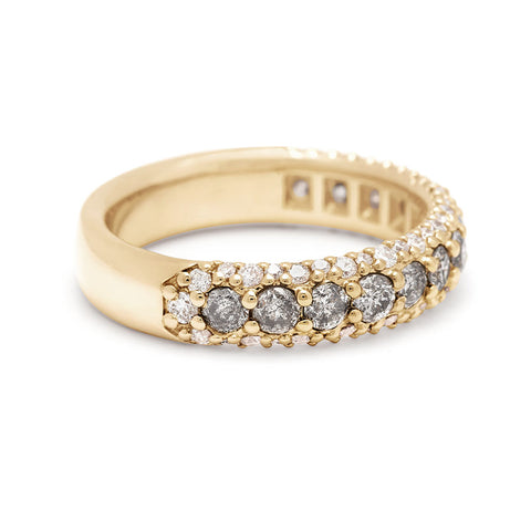 Angled view of a band with round grey diamonds in a 3/4 pave around a yellow gold band with white diamond accents on both top and bottom. 2