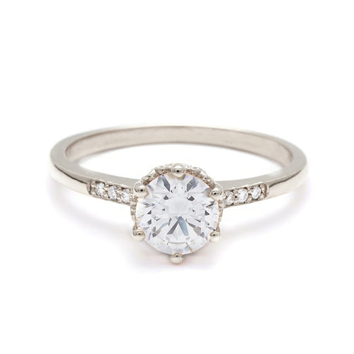 A solitaire ring with a round brilliant cut 0.75ct white diamond with white diamond pave on either side set in white gold., White Gold