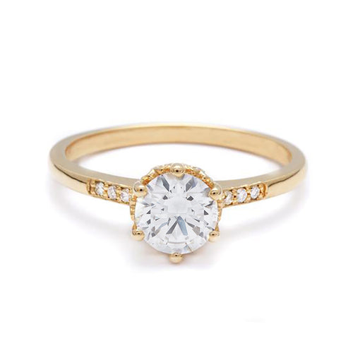 A solitaire ring with a round brilliant cut 0.75ct white diamond with white diamond pave on either side set in yellow gold., Yellow Gold