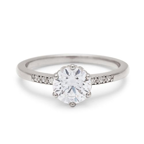 A solitaire ring with a round shape 1.00ct white diamond with white diamond pave on either side set in white gold., White Gold