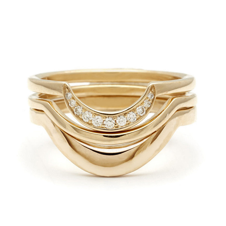 Two solid yellow gold curve bands stacked beneath a crescent shaped white diamond band in yellow gold.