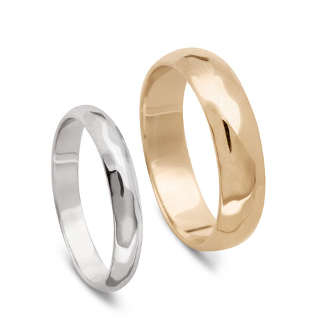 A 3mm classic round band with a hammered finish set in white gold next to a 5mm classic round band with a hammered finish set in yellow gold.