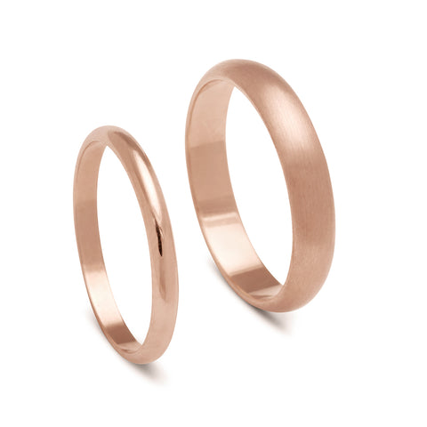 A 2mm classic round band set in rose gold next to a 4mm classic round band with a brushed finish set in rose gold.