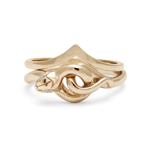 A serpent band with white diamond eyes set in yellow gold stacked below a solid gold nesting band.