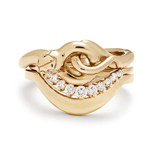 A serpent band with two white diamonds for eyes stacked above an 11 white diamond curve band and a tapered solid gold band in yellow gold.
