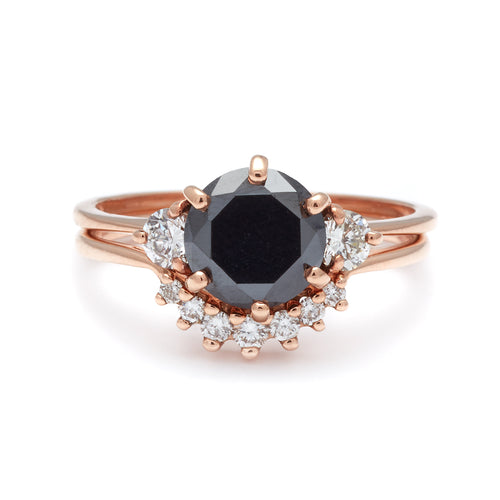 A three stone engagement ring with a round shape black diamond center stone with two white diamond round side stones set in rose gold stacked above a small 7 white diamond curve band in rose gold., White Gold, Rose Gold, Yellow Gold