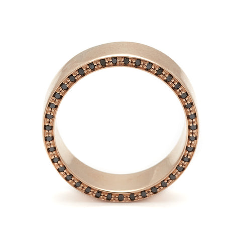 Side view of a 7mm flat band with black diamond accents around the band set in rose gold. 2