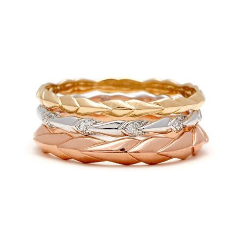 Three straight bands with leaf like definition one with white diamond accent stones. 4