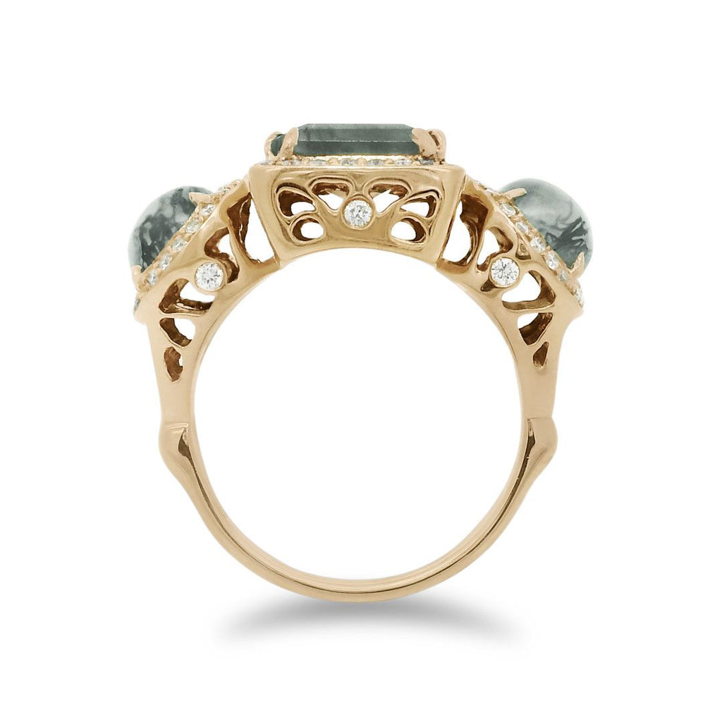 Side profile of a moss agate ring encircled with white diamond pavé set in 14kt yellow gold. 