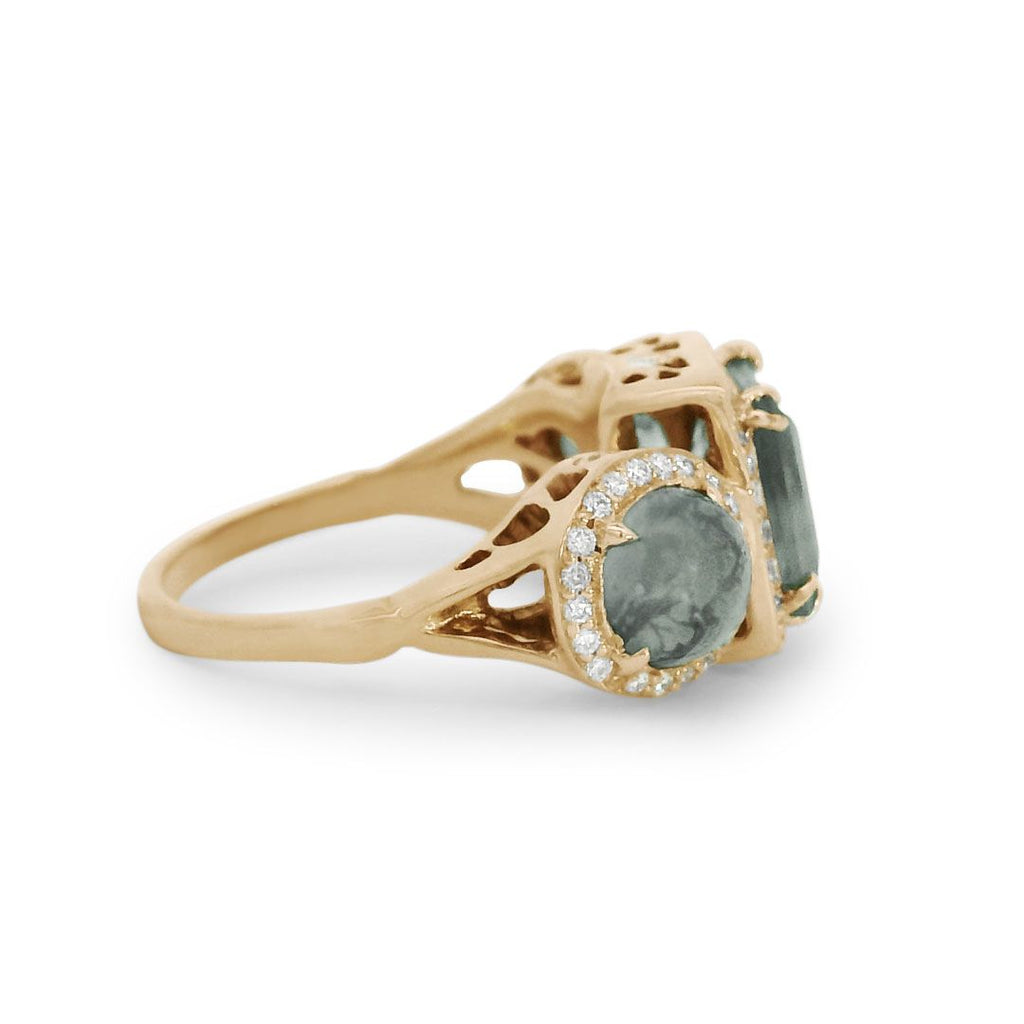 Side profile of a moss agate ring encircled with white diamond pavé set in 14kt yellow gold. 