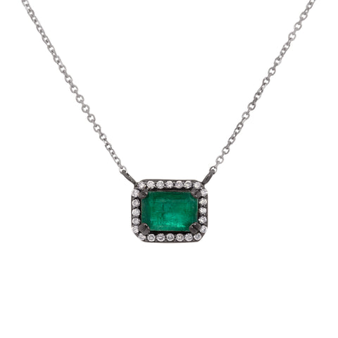 White gold necklace with a green emerald gemstone and white diamond accents on a white background