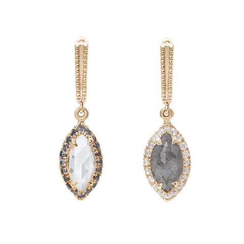 A pair of drop earrings with a U shaped hoop. One earring has white diamond pave and a marquise shaped grey diamond, the other has grey diamond pave and a marquise shaped white diamond set in yellow gold.