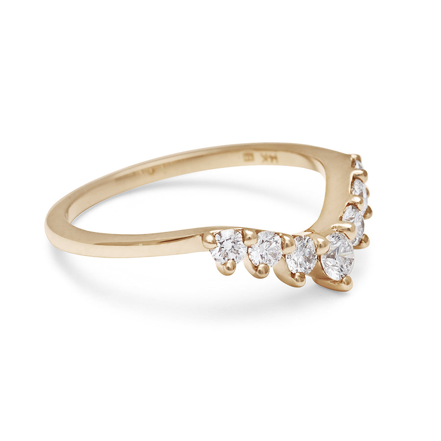 Angled view of a curved 7 white diamond band set in yellow gold.