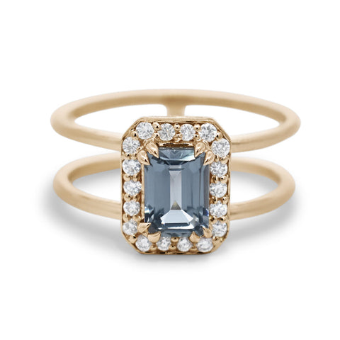 Gold ring with a blue gemstone and diamond accents on a white background