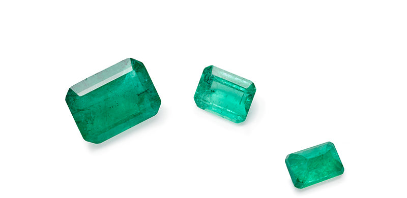3 emerald stones that gradually decrease in size from left to right.