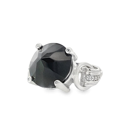 Angled view of a harness ring with a round black spinel with a decorated band set in sterling silver.