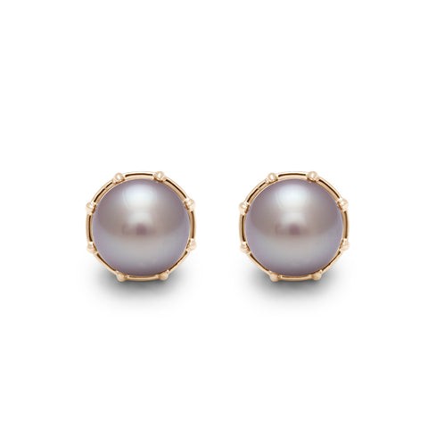 A pair of lilac pearl studs set in yellow gold.
