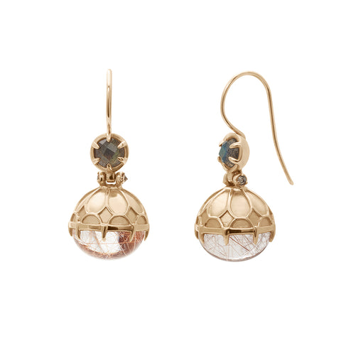 A pair of drop earrings with a copper rutilated quartz hanging from them with a labradorite accent stone set in yellow gold one earring angled.