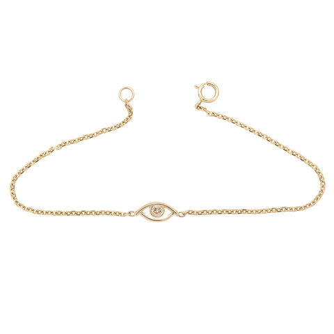 An evil eye charm with a champagne diamond center set in yellow gold on a yellow gold chain bracelet.