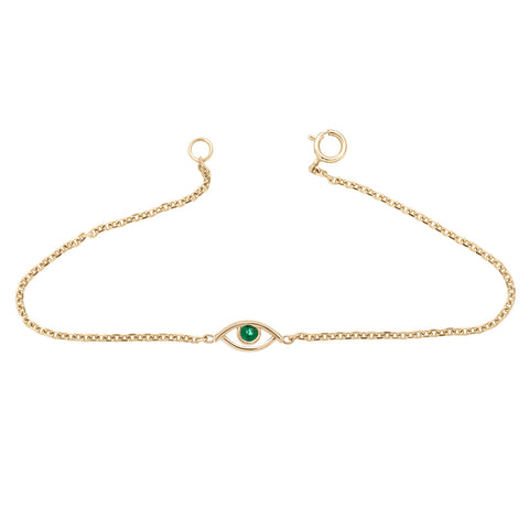 An evil eye charm with an emerald stone center set in yellow gold on a yellow gold chain bracelet.