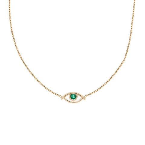 A choker with an evil eye charm with an emerald stone in the center set on a yellow gold chain.