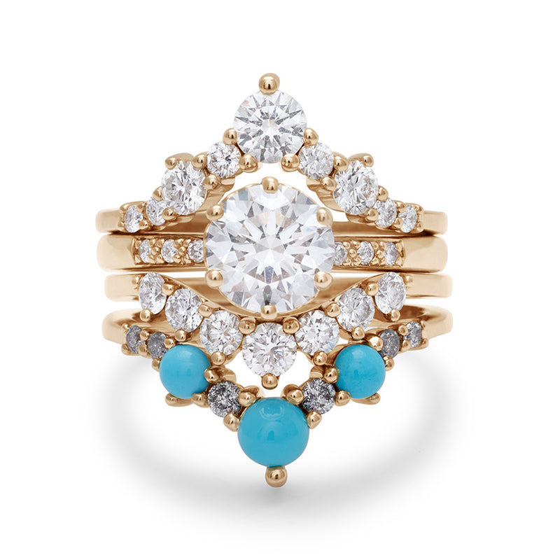 A solitaire round white diamond engagement ring stacked between two chevron bands and a curve band with white diamonds and turquoise stones.