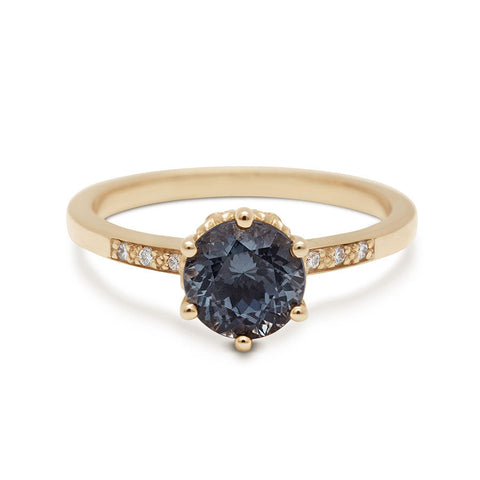 A solitaire ring with a round grey spinel with white diamond pave on either side set in yellow gold., Yellow Gold