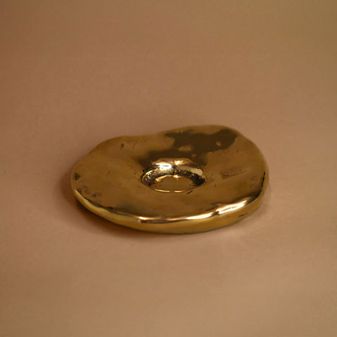 Brozne decorative cone incense burner object on a beige background