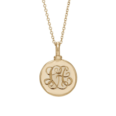 A 18mm charm with interlocking monogrammed engraved on the front set in yellow gold on a yellow gold chain.