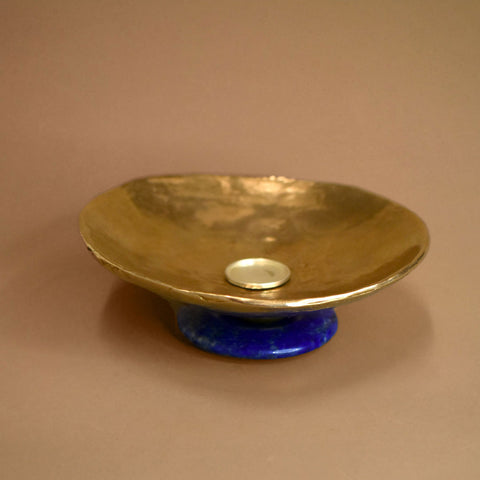 Bronze dish with a lapis lazuli base on a beige background