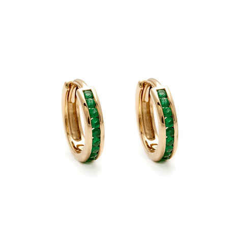 A pair of hoops with a line of emeralds set in yellow gold.