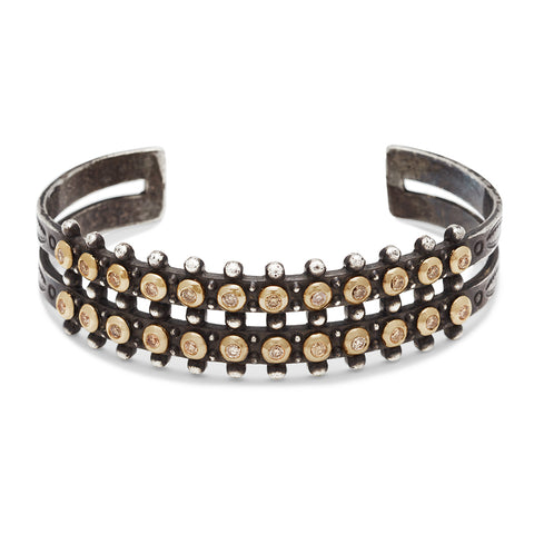A sterling silver cuff with two rows of champagne diamonds bezel set in yellow gold.