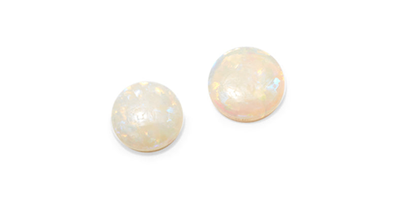 2 Opal cabachons on a flat surface and white background