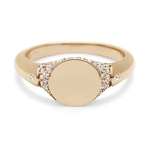 A solid gold signet ring with two white diamond accents on either side and a pave set around the top of the ring and set in yellow gold.