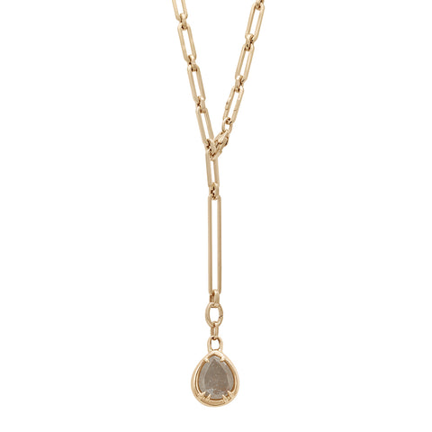 A zoomed out view of a grey diamond charm in a bezel setting with claw prongs set in yellow gold on a mixed link yellow gold chain.