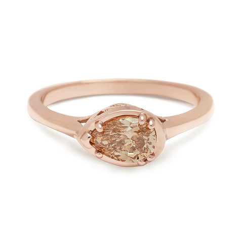 A pear shaped ring with a champagne diamond set in rose gold.