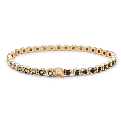 A rotated view of a line bracelet with grey, white and black diamonds set in eternity with rhodium set in yellow gold.